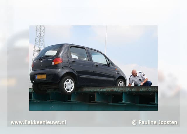 Auto bungelt op rand van brug