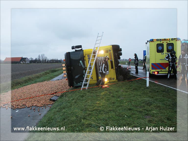 Trekker-oplegger met uien gekanteld