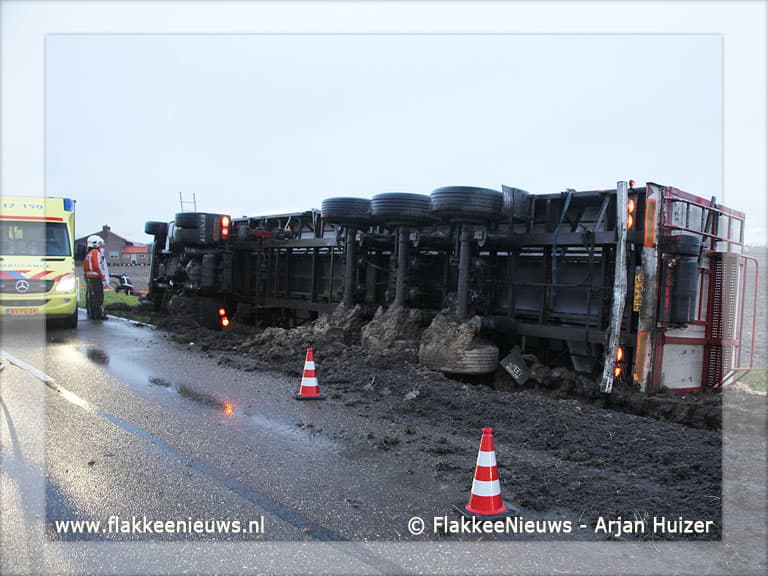 Trekker-oplegger met uien gekanteld