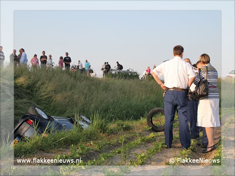 Auto van de dijk en belandt in sloot