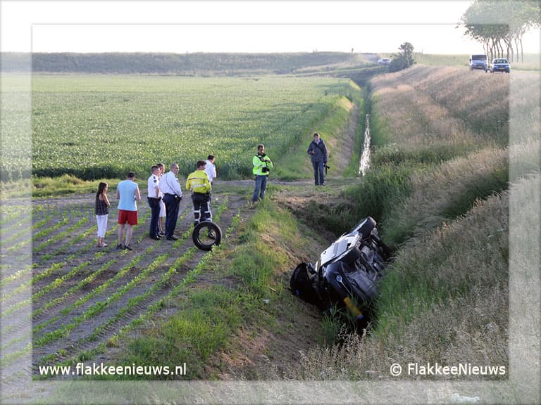 Auto van de dijk en belandt in sloot
