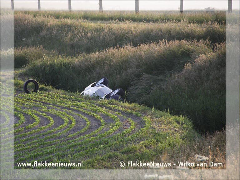 Auto van de dijk en belandt in sloot