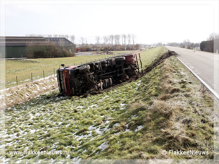 Volgeladen vrachtwagen van de dijk