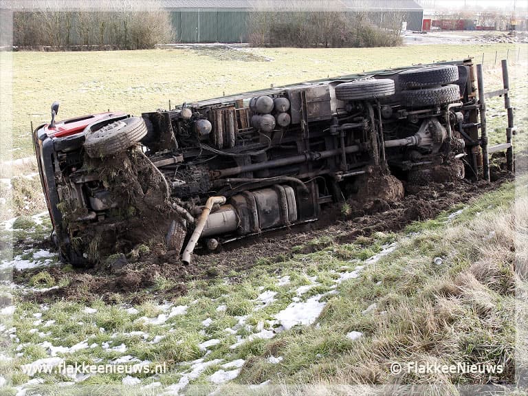 Volgeladen vrachtwagen van de dijk