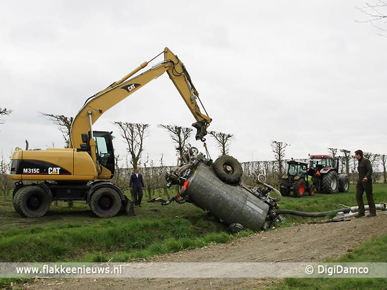Tractor met giertank in de sloot