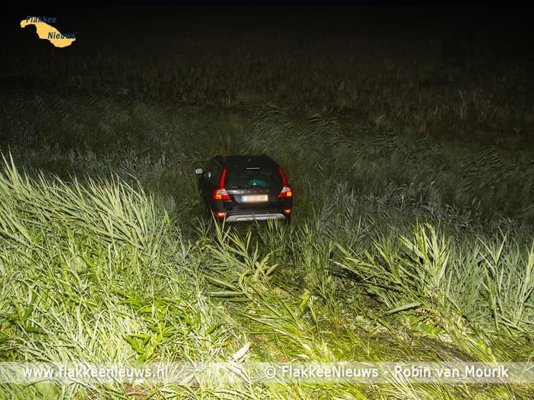 Hulpdiensten rukken uit voor auto naast de dijk