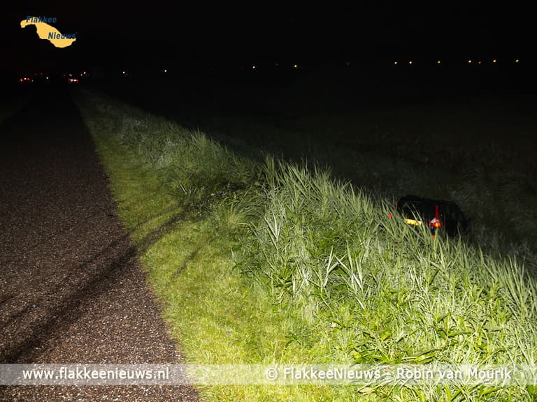 Hulpdiensten rukken uit voor auto naast de dijk