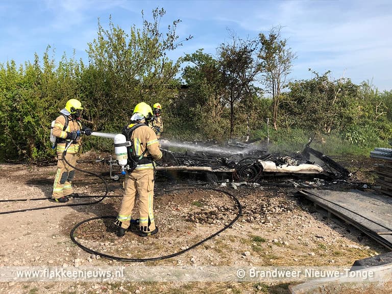 Caravan in brand en auto op z'n kant