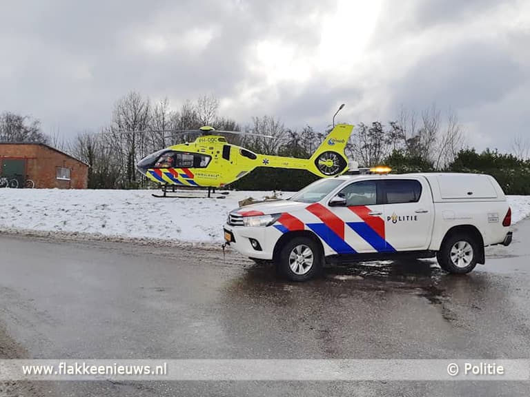 Gladde wegen en kind met slee onder auto