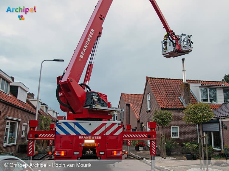 Vlammen uit schoorsteen, brandweer rukt uit