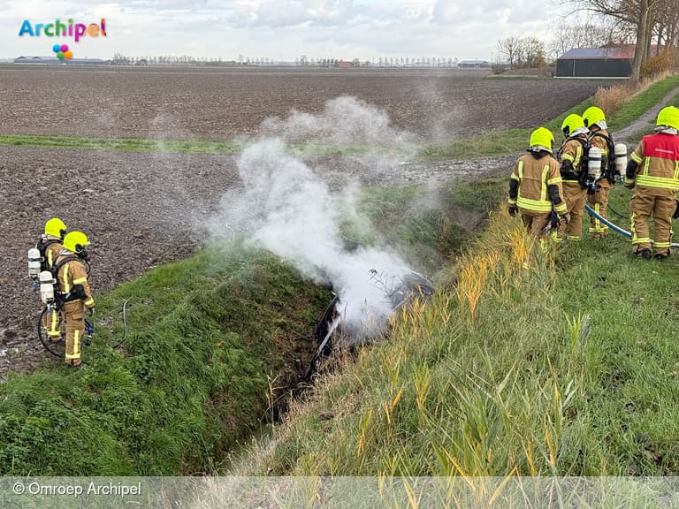 Auto van de dijk en in brand bij Herkingen