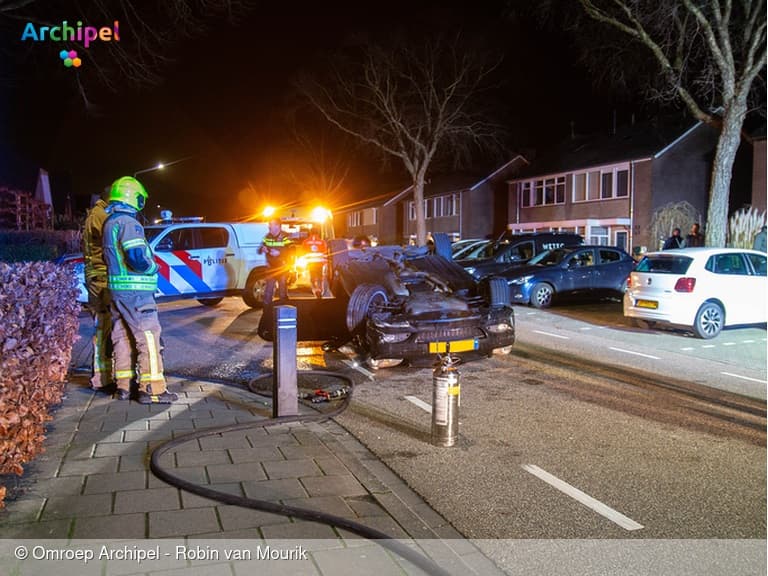 Auto raakt geparkeerde voertuigen en slaat over de kop