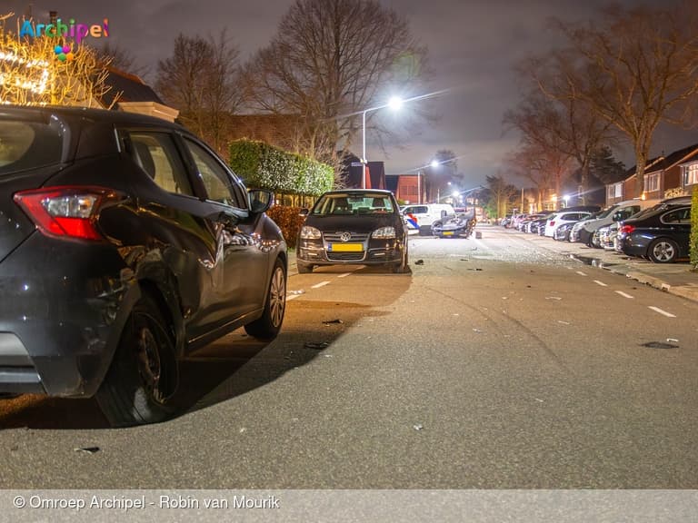 Auto raakt geparkeerde voertuigen en slaat over de kop