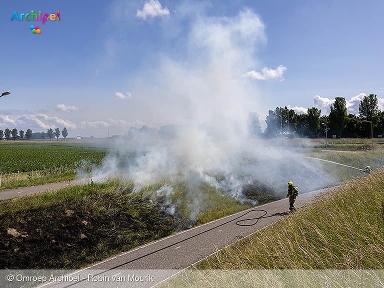 Brandweer blust bermbrand bij fietstunnel
