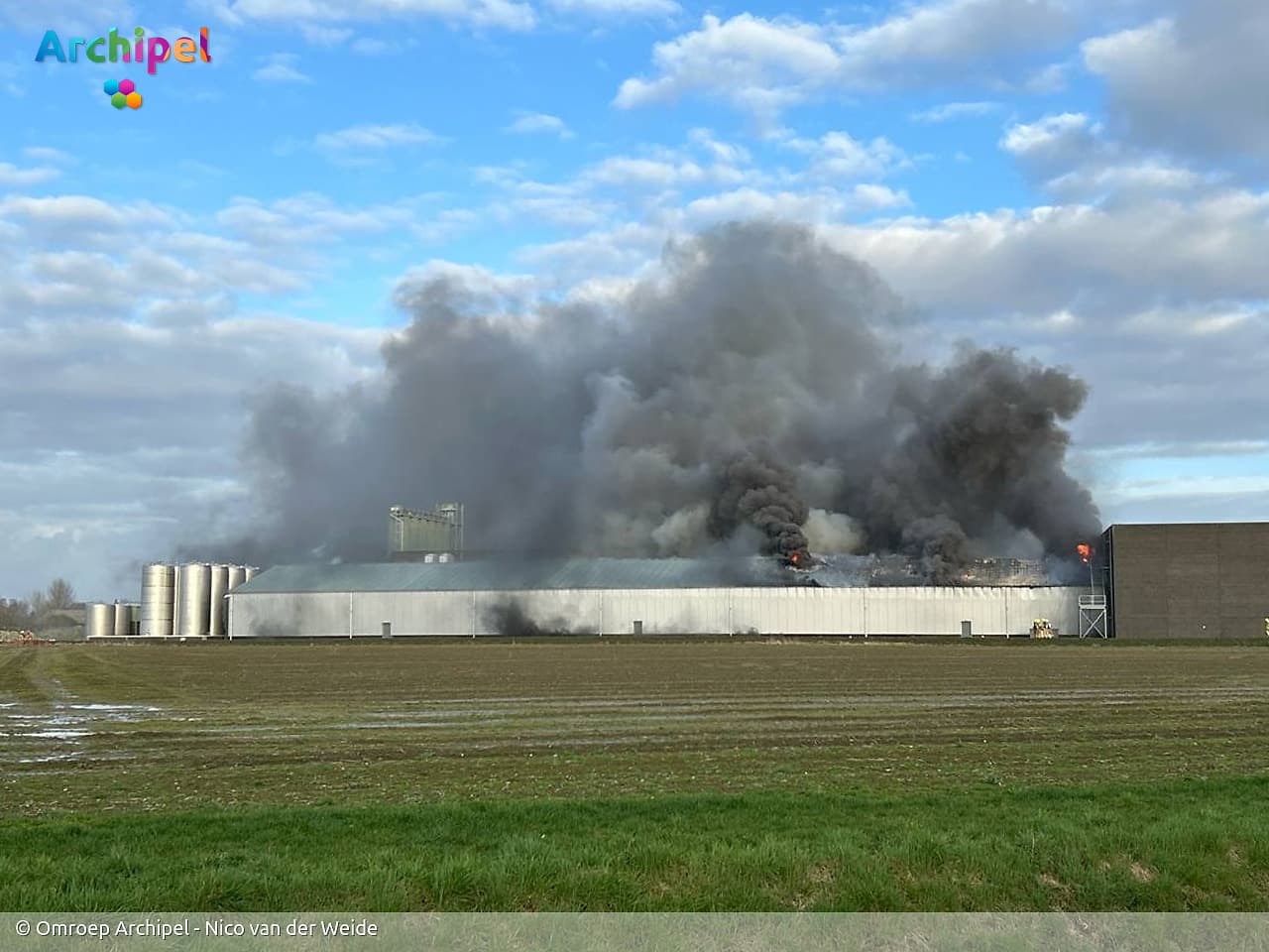 Vlammen slaan uit dak van brandende loods