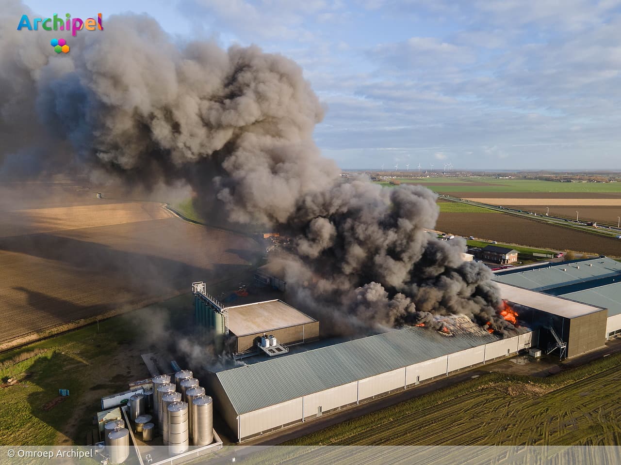 Vlammen slaan uit dak van brandende loods