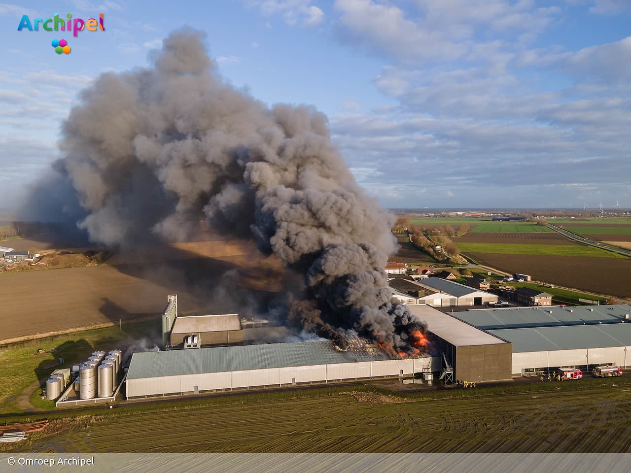 Vlammen slaan uit dak van brandende loods