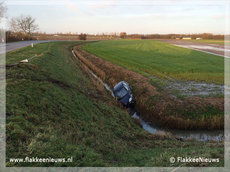 Auto belandt naast de dijk