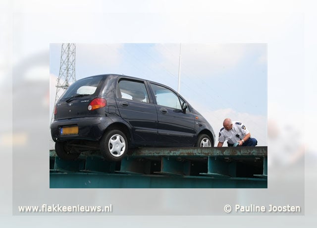 Auto bungelt op rand van brug