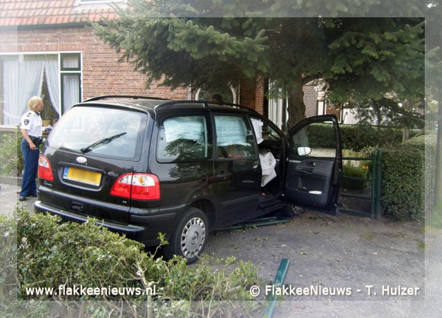 Bestuurder rijdt met auto tuin in