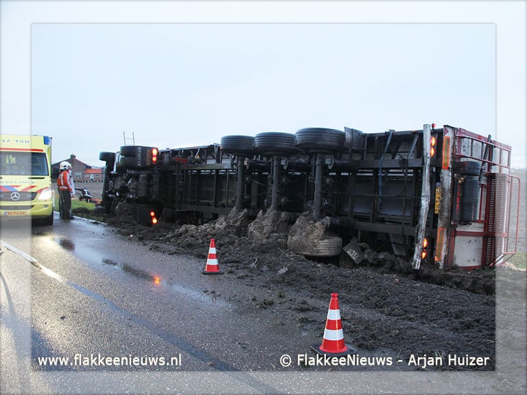 Trekker-oplegger met uien gekanteld