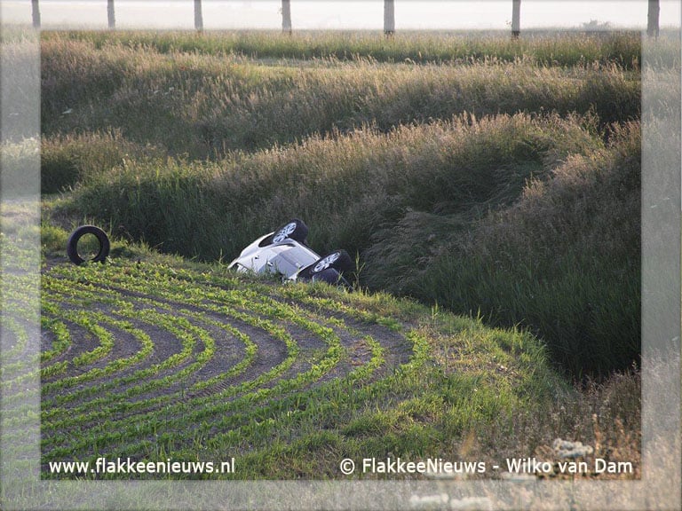 Auto van de dijk en belandt in sloot