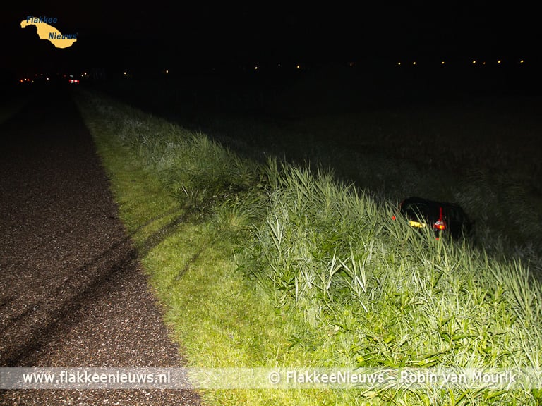 Hulpdiensten rukken uit voor auto naast de dijk