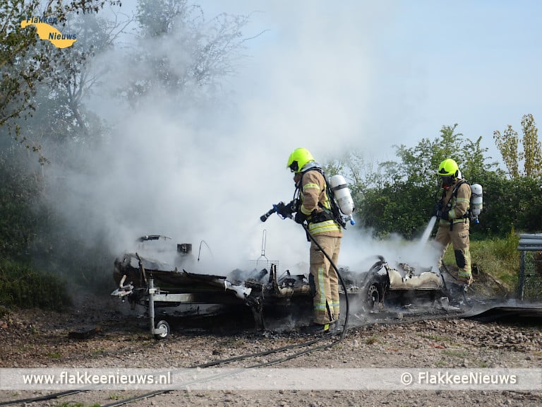 Caravan in brand en auto op z'n kant