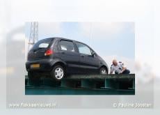 Auto bungelt op rand van brug