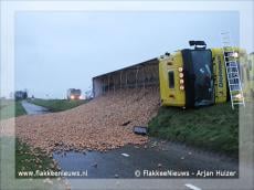 Trekker-oplegger met uien gekanteld