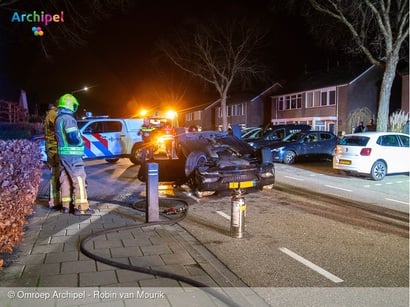 Auto raakt geparkeerde voertuigen en slaat over de kop