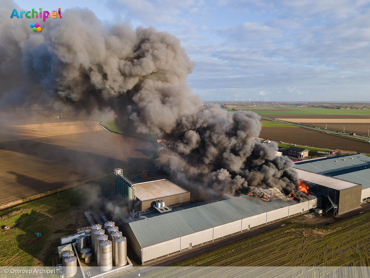 Vlammen slaan uit dak van brandende loods